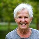 Portrait of Susan, a vibrant senior woman smiling warmly outdoors.